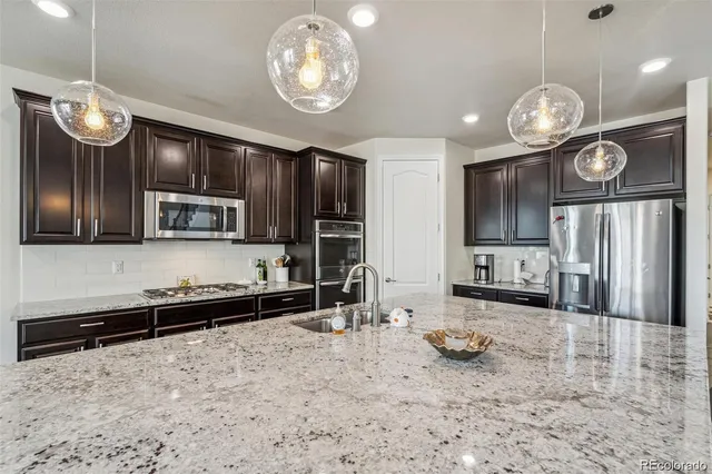 a view of a kitchen with granite countertop stainless steel appliances and a table