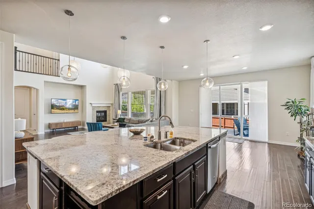 a kitchen with granite countertop kitchen island stainless steel appliances a sink and living room view