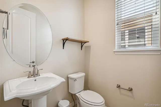 a bathroom with a sink a toilet and a mirror