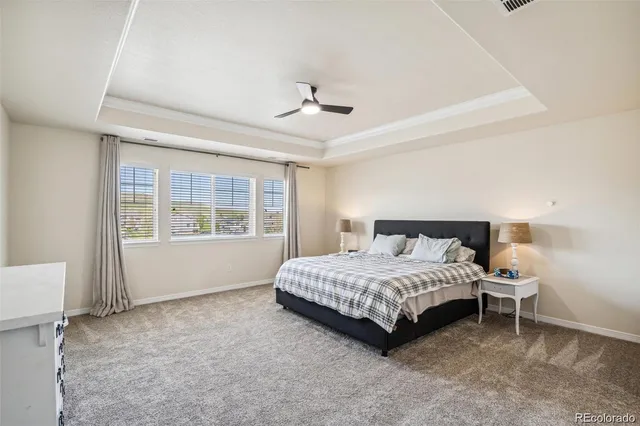 a bedroom with a bed chandelier and a window