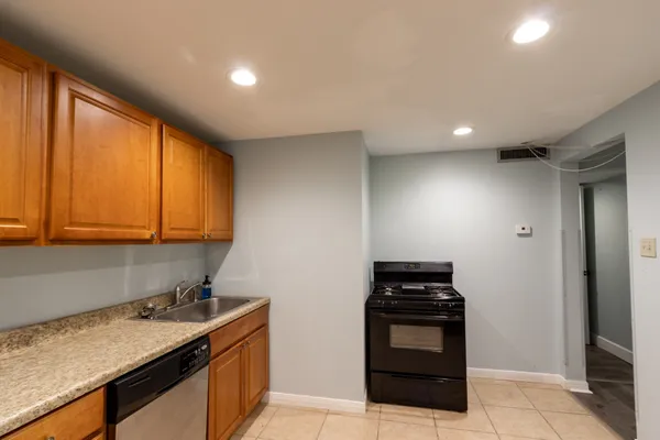 a kitchen with stainless steel appliances granite countertop a sink and a refrigerator