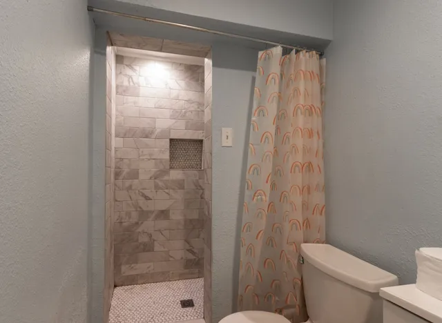 a bathroom with a toilet sink vanity and mirror