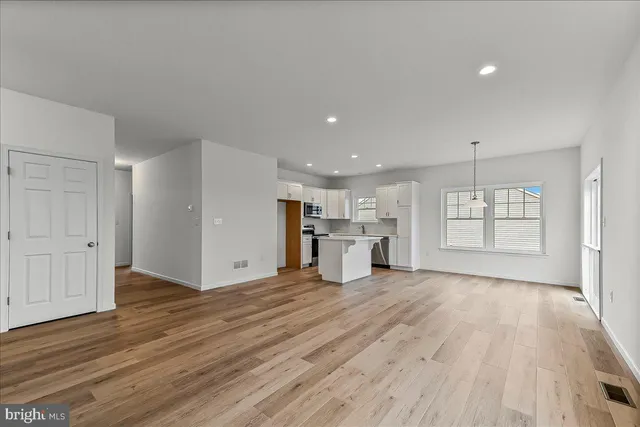 a view of a kitchen with wooden floor and window
