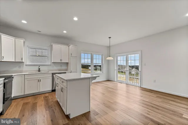 a large kitchen with cabinets wooden floor and stainless steel appliances