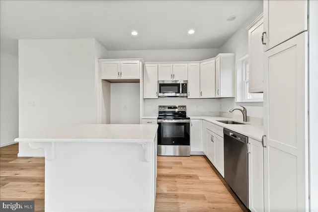a kitchen with stainless steel appliances a refrigerator sink and stove