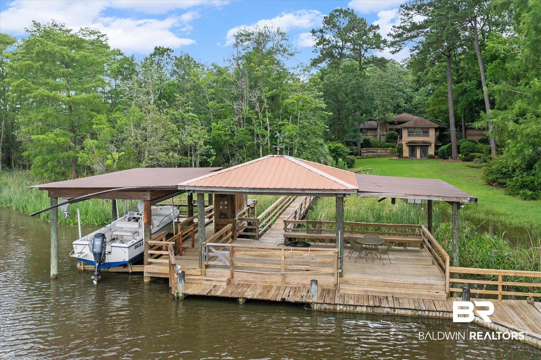 3500 Venetia Road Mobile, AL 36605 - Photo 44 of 56 Waterfront dock with covered boat slip, expansive wood decking, built-in benches, and a metal roof
