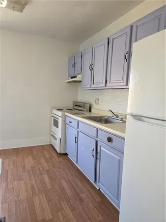 a kitchen with a sink a refrigerator and cabinets