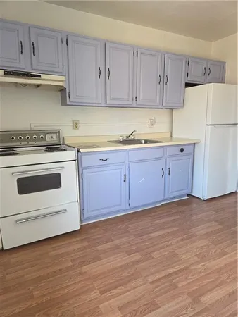 a kitchen with granite countertop white cabinets and white appliances