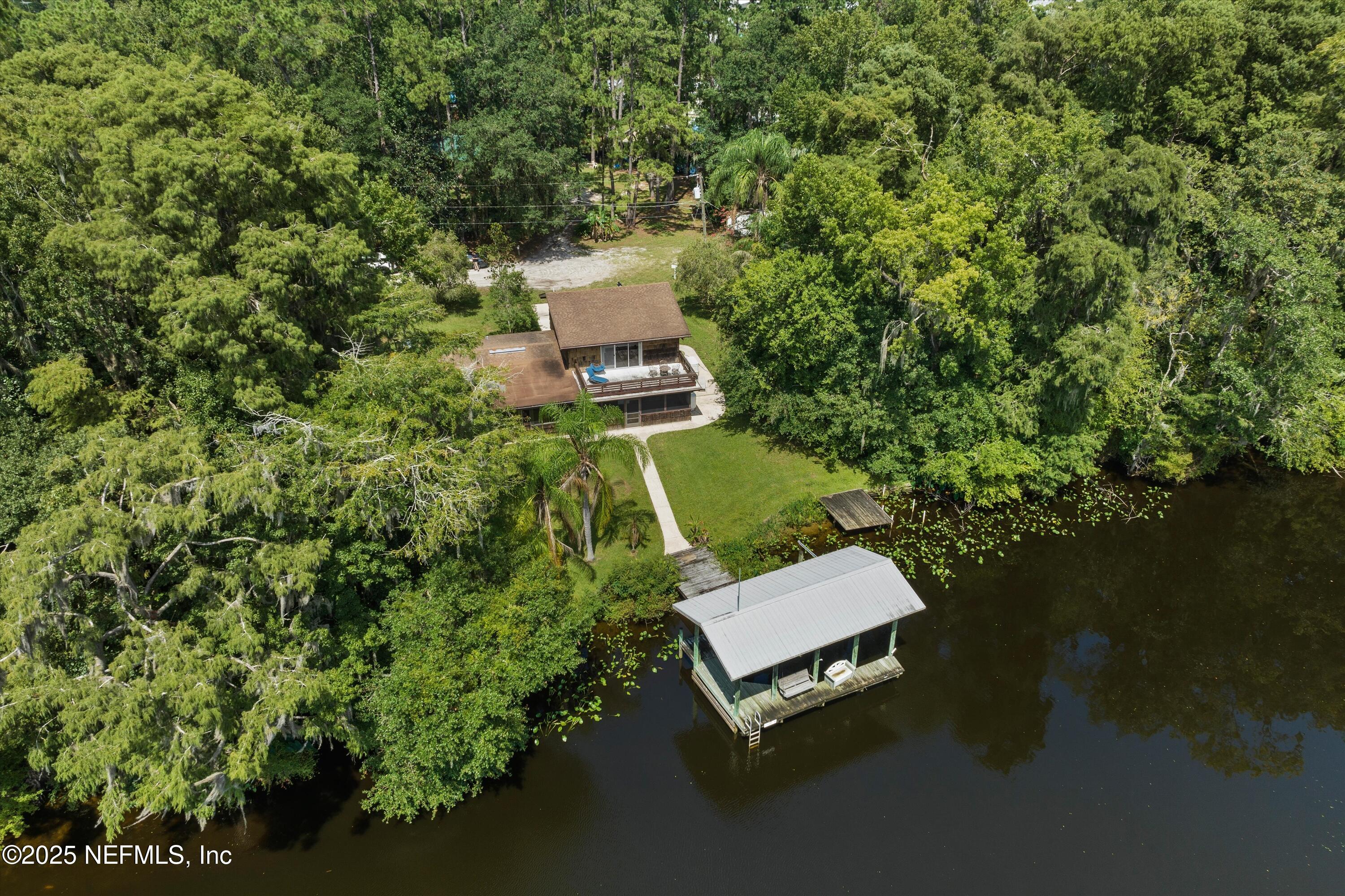 145 Finnigan Road Satsuma, FL 32189 - Photo 1 of 33 a wooden bench sitting in the middle of a river
