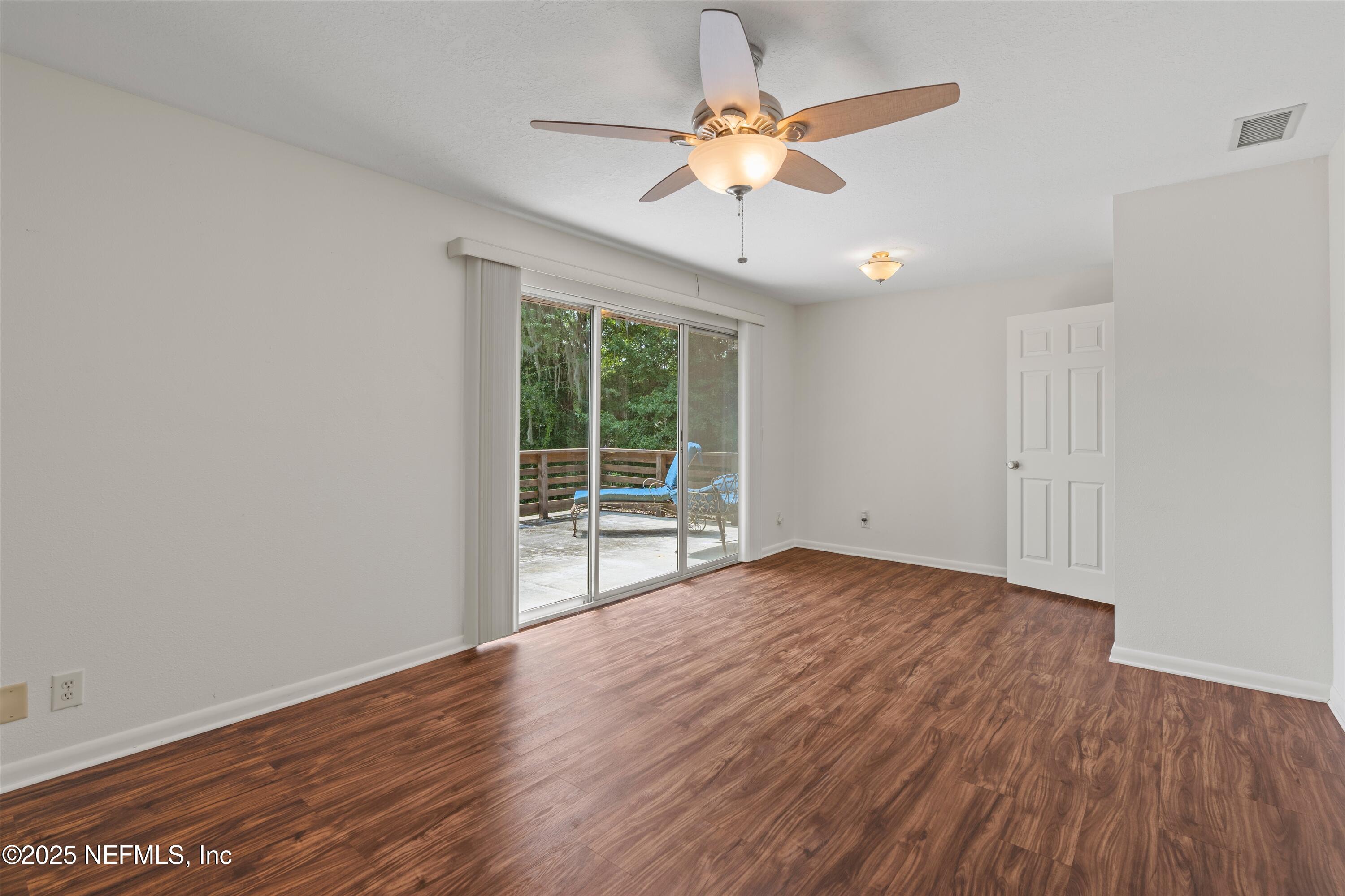 145 Finnigan Road Satsuma, FL 32189 - Photo 16 of 33 an empty room with wooden floor and windows