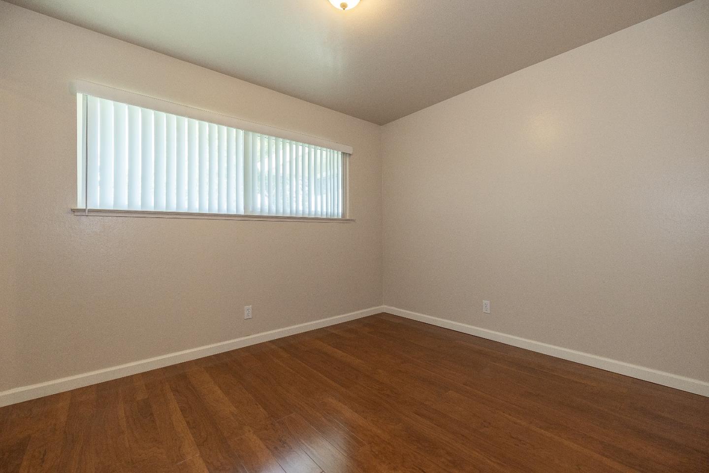 207 Watson Drive, Unit 1 Campbell, CA 95008 - Photo 11 of 17 wooden floor in an empty room with a window