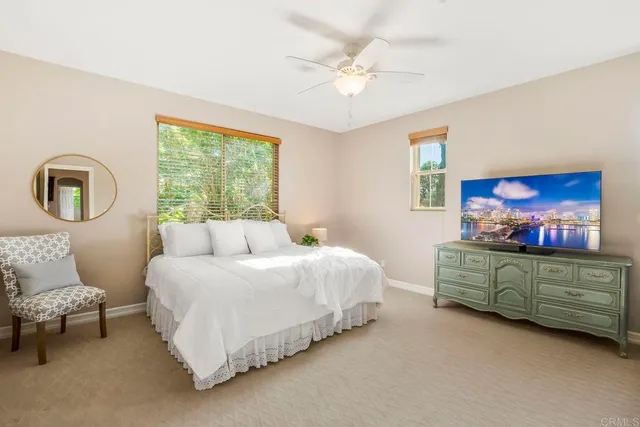 a bedroom with a large bed and a ceiling fan