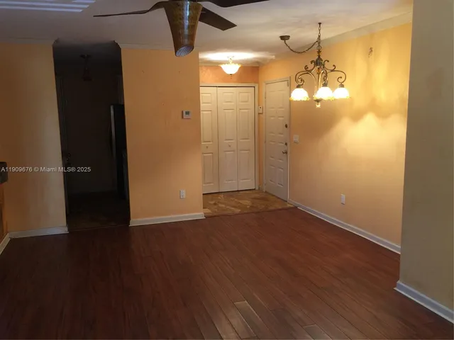 an empty room with wooden floor and a bathroom