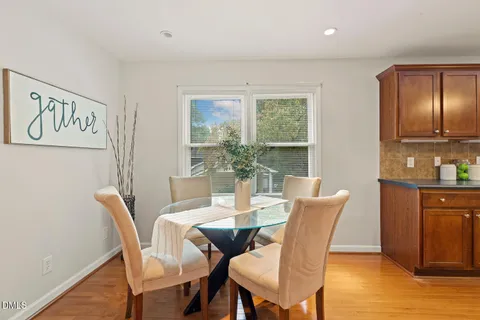 a kitchen with stainless steel appliances granite countertop wooden cabinets a refrigerator a sink a stove and a wooden floors