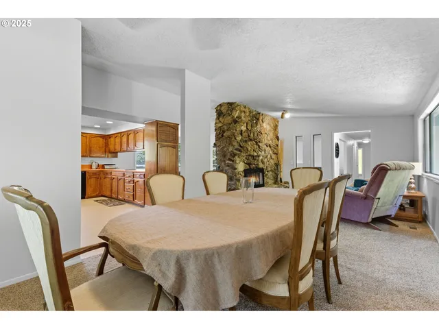 a living room with stainless steel appliances kitchen island granite countertop a sink and cabinets