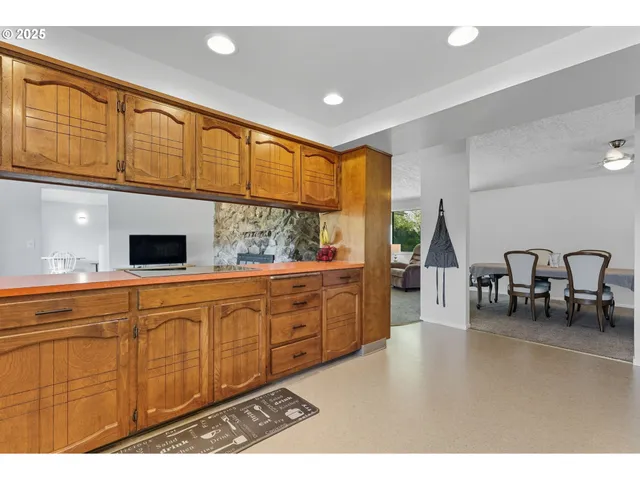 a kitchen with stainless steel appliances kitchen island granite countertop a refrigerator and cabinets