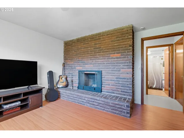 a view of a yard with plants and large trees