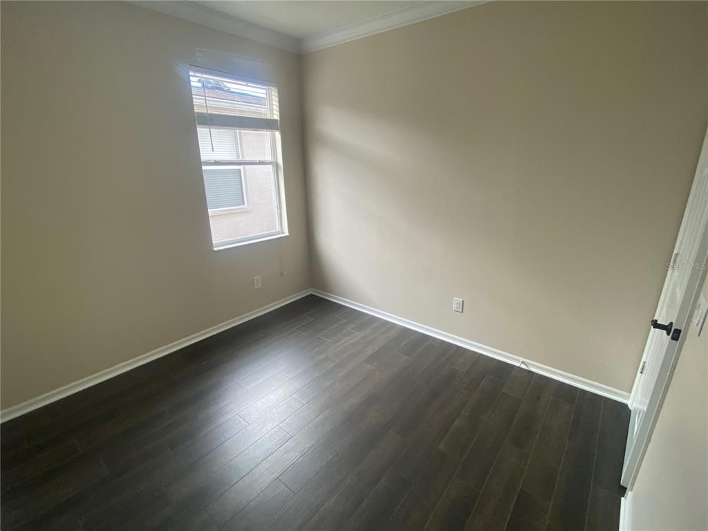 2409 Spring Hollow Loop Wesley Chapel, FL 33544 - Photo 14 of 47 an empty room with wooden floor and windows