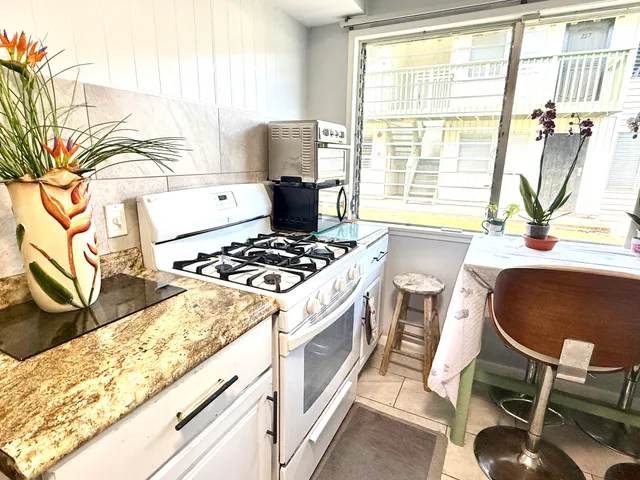 a kitchen with a stove a table and chairs in it