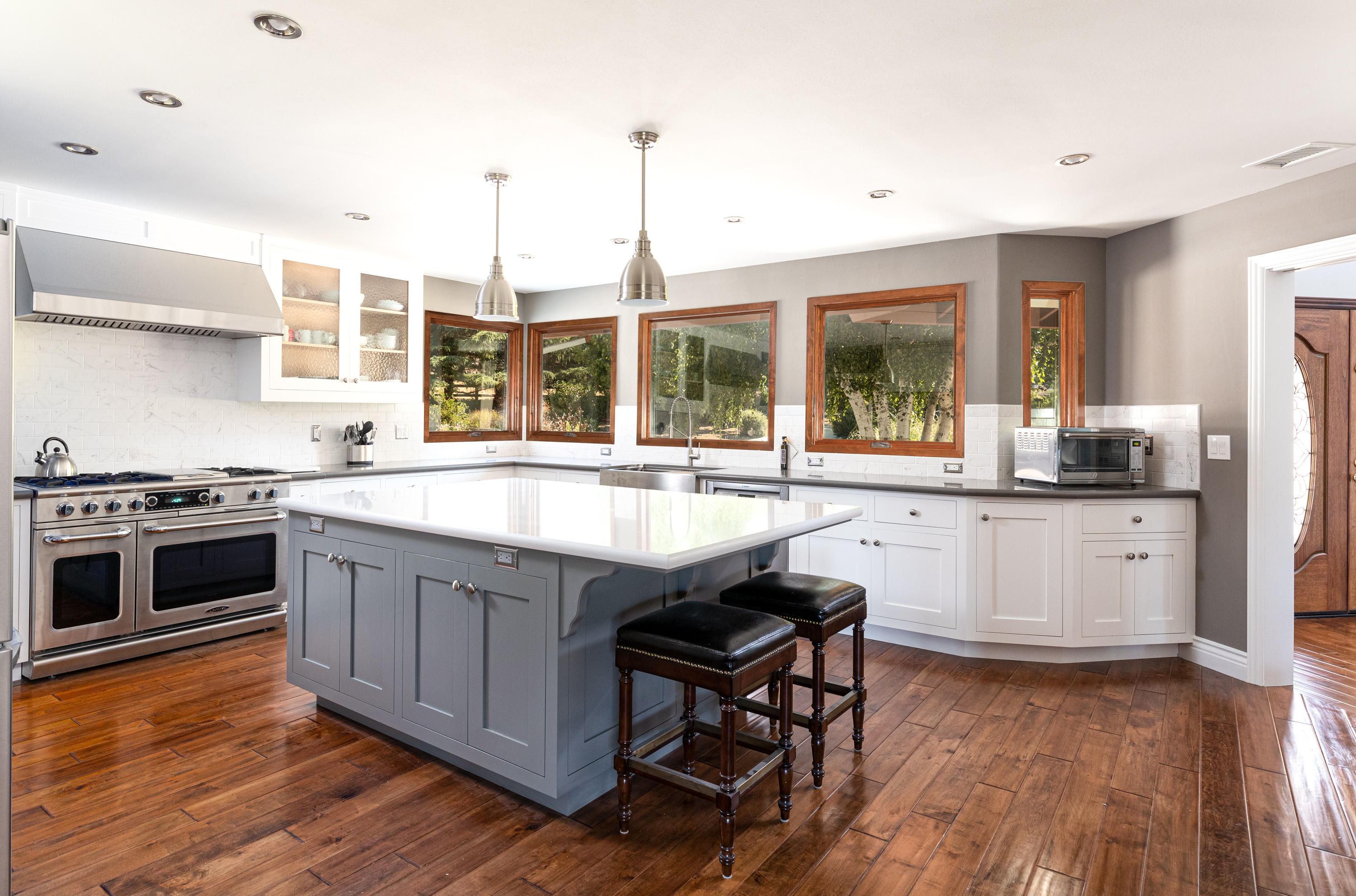 705 Mesa Drive Solvang, CA 93463 - Photo 6 of 22 a kitchen with stainless steel appliances granite countertop wooden floors and white cabinets