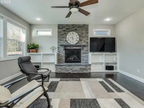 a living room with furniture and kitchen view with wooden floor
