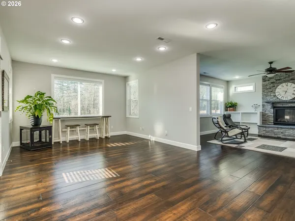 a kitchen with stainless steel appliances granite countertop a refrigerator a sink dishwasher a stove and white countertops with wooden floor