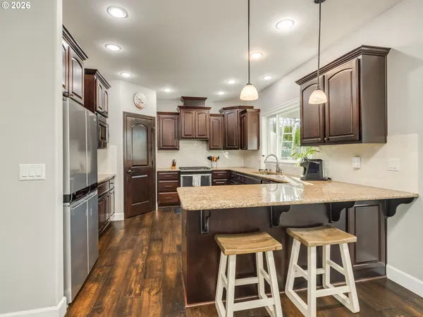 a kitchen with stainless steel appliances granite countertop a refrigerator sink and stove