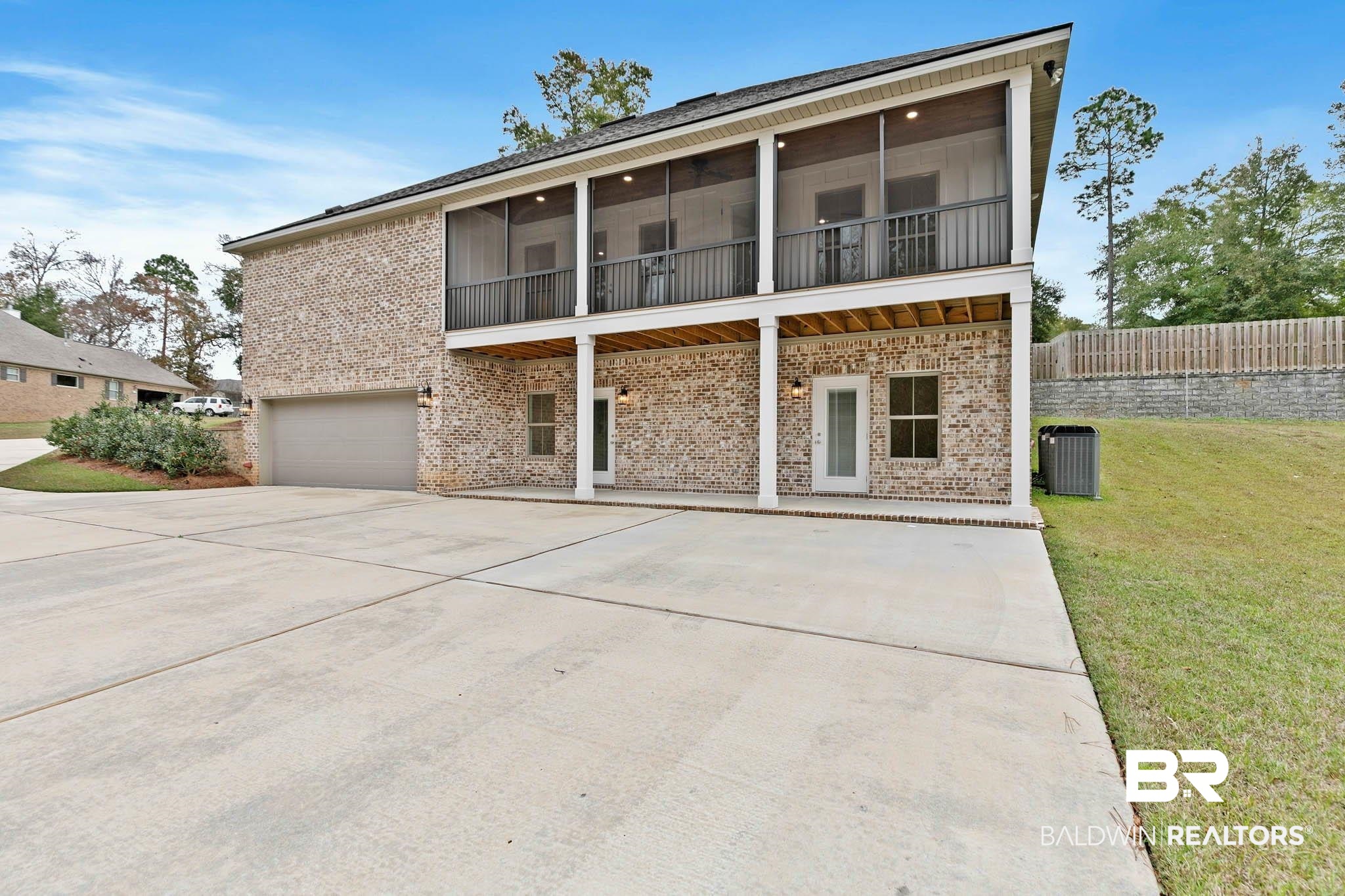 6656 Garrison Drive Daphne, AL 36527 - Photo 46 of 57 Back of property featuring brick siding, a balcony, driveway, a garage, and a patio