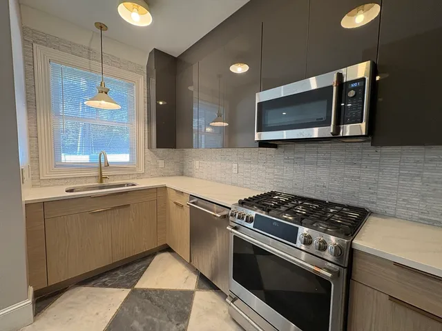 a kitchen with stainless steel appliances granite countertop a stove microwave and sink