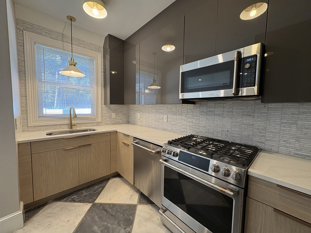 a kitchen with stainless steel appliances granite countertop a stove microwave and sink