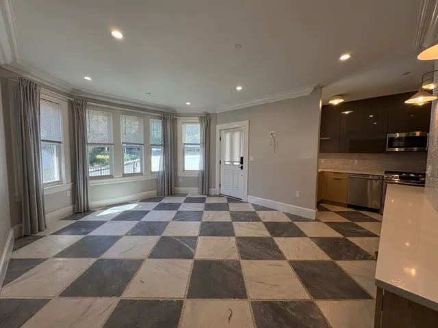 a view of a black and white checkered floor with a rug