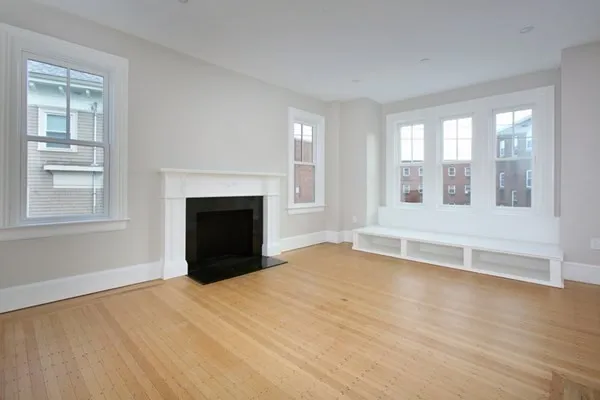 a view of an empty room with a window and fireplace