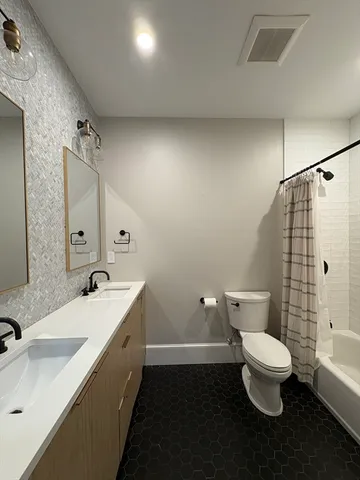 a bathroom with a double vanity sink toilet and shower