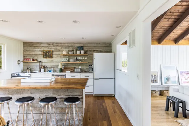 a view of a kitchen with kitchen island and stainless steel appliances