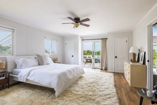 a bedroom with a bed flat screen tv and a large window