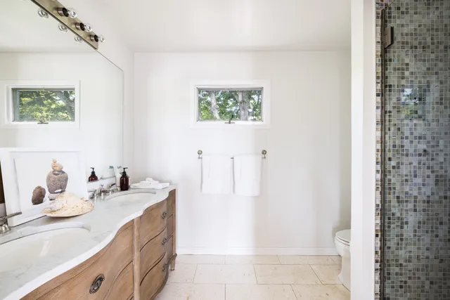 a bathroom with a sink a toilet and a mirror