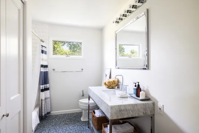 a bathroom with a sink a mirror and a toilet