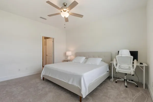 a bedroom with a bed and a ceiling fan
