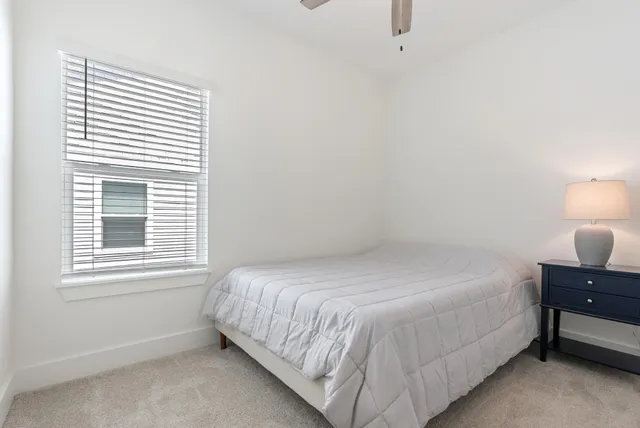 a bedroom with a bed and window with lamp