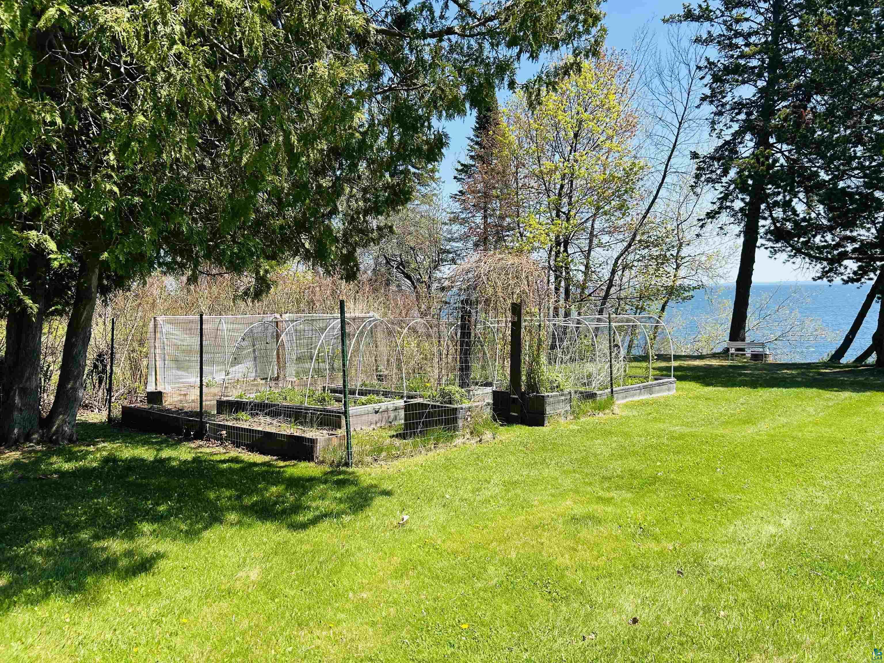 5090 London Road, Unit 1 Duluth, MN 55804 - Photo 43 of 54 Expansive lawn featuring multiple raised garden beds with protective covers