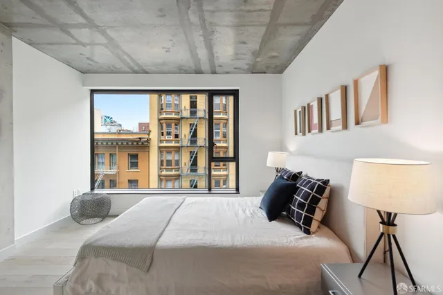 a large bedroom with a bed and wooden floor