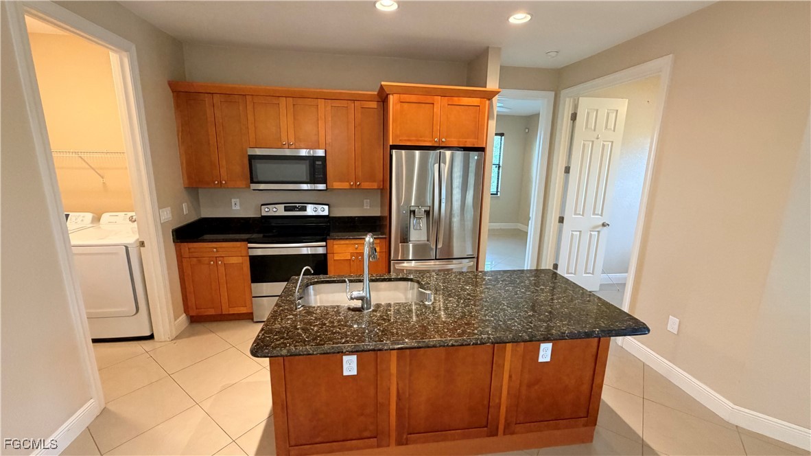 4310 4th Street Southwest Lehigh Acres, FL 33976 - Photo 7 of 27 a kitchen with a sink a stove and a refrigerator