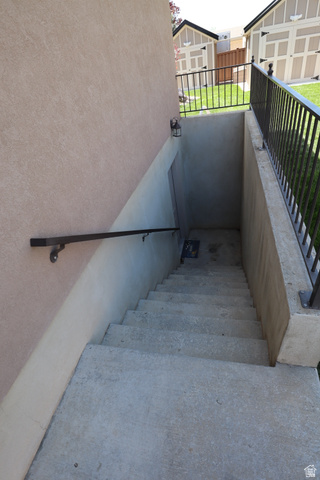 1055 North 1000 East Mapleton, UT 84664 - Photo 104 of 112 Exterior concrete stairs featuring a black metal handrail and a stucco-finish wall