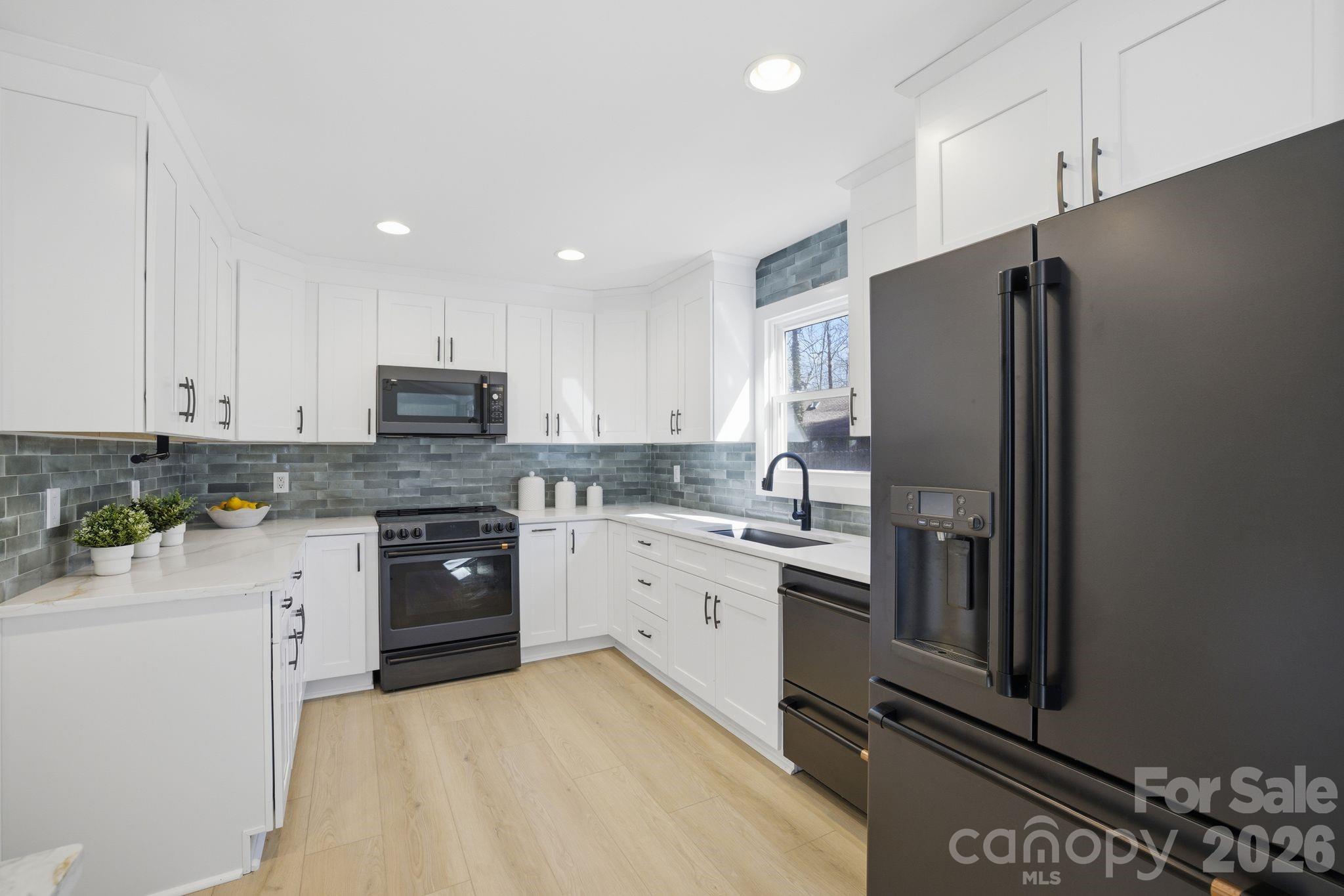 21326 Sandy Cove Road Cornelius, NC 28031 - Photo 6 of 21 a kitchen with granite countertop white cabinets and stainless steel appliances