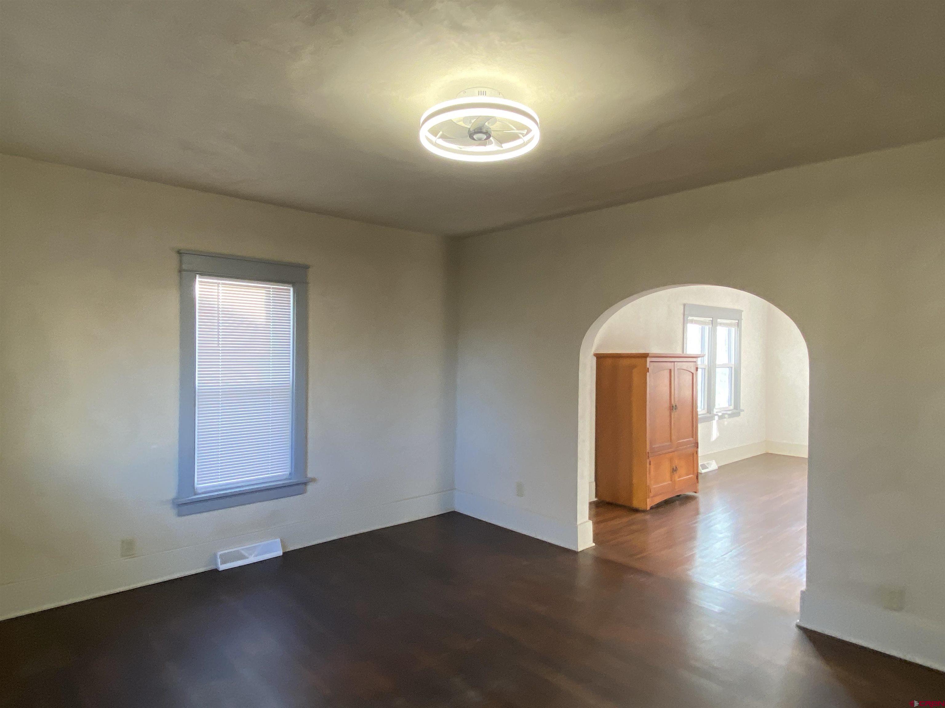121 South Washington Street Cortez, CO 81321 - Photo 17 of 33 an empty room with wooden floor and windows