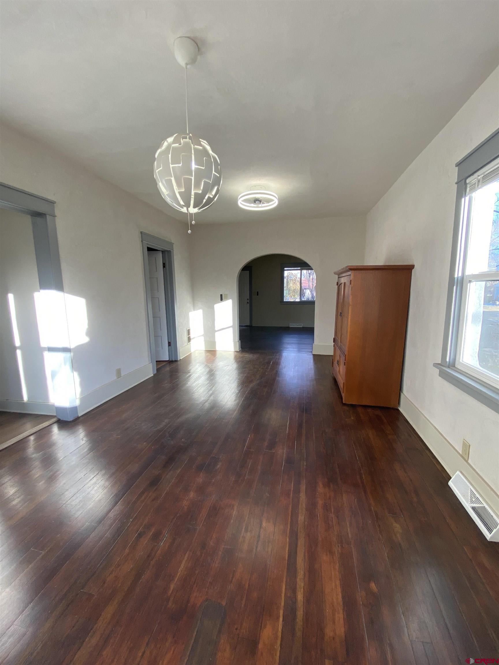 121 South Washington Street Cortez, CO 81321 - Photo 18 of 33 an empty room with wooden floor and windows