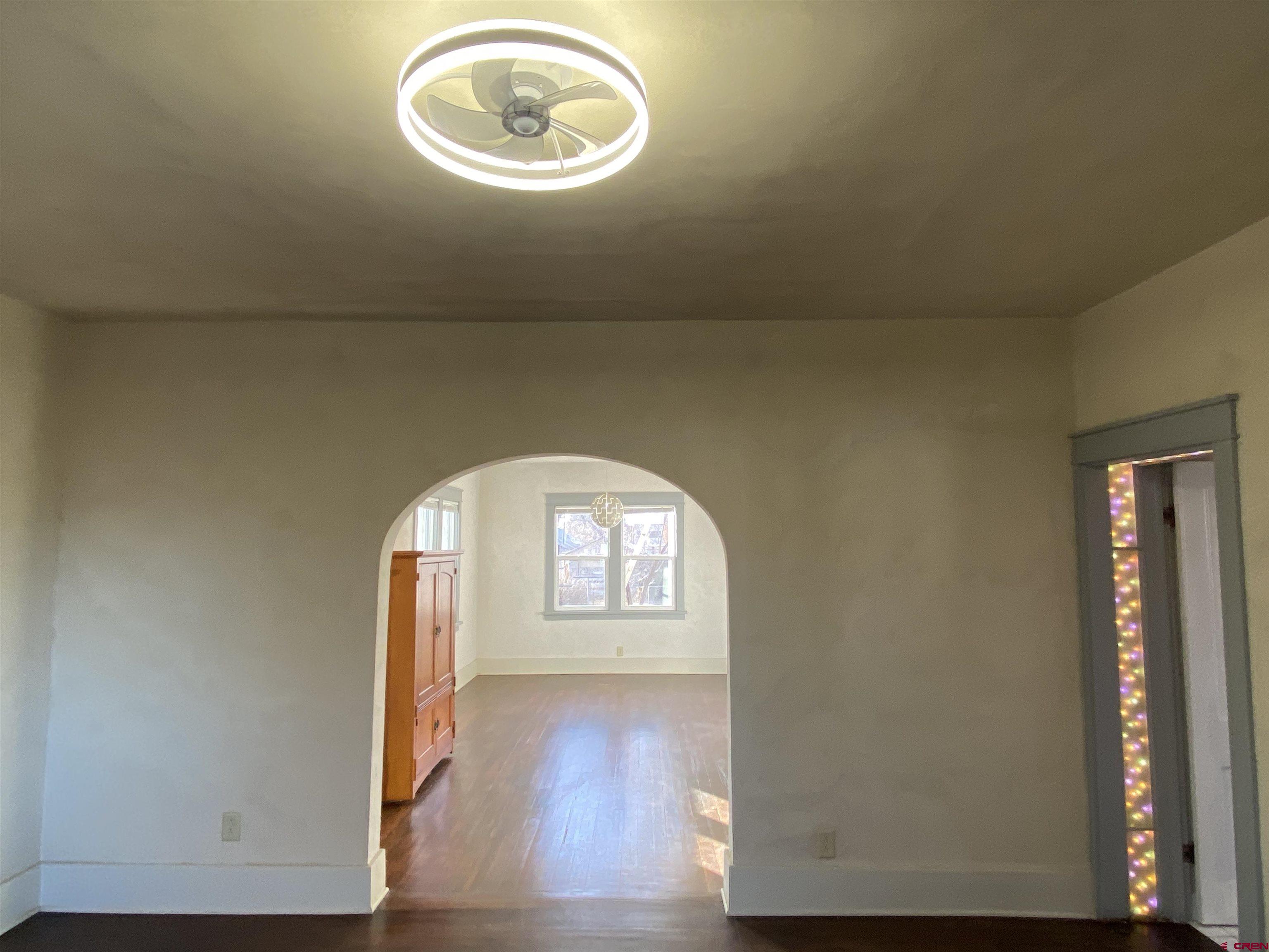 121 South Washington Street Cortez, CO 81321 - Photo 10 of 33 an empty room with wooden floor and windows