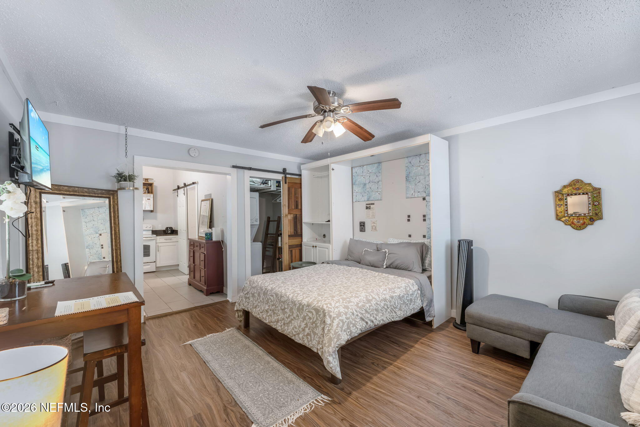 909 Cedar Street Jacksonville, FL 32207 - Photo 28 of 41 a bedroom with a bed a couch and a chandelier
