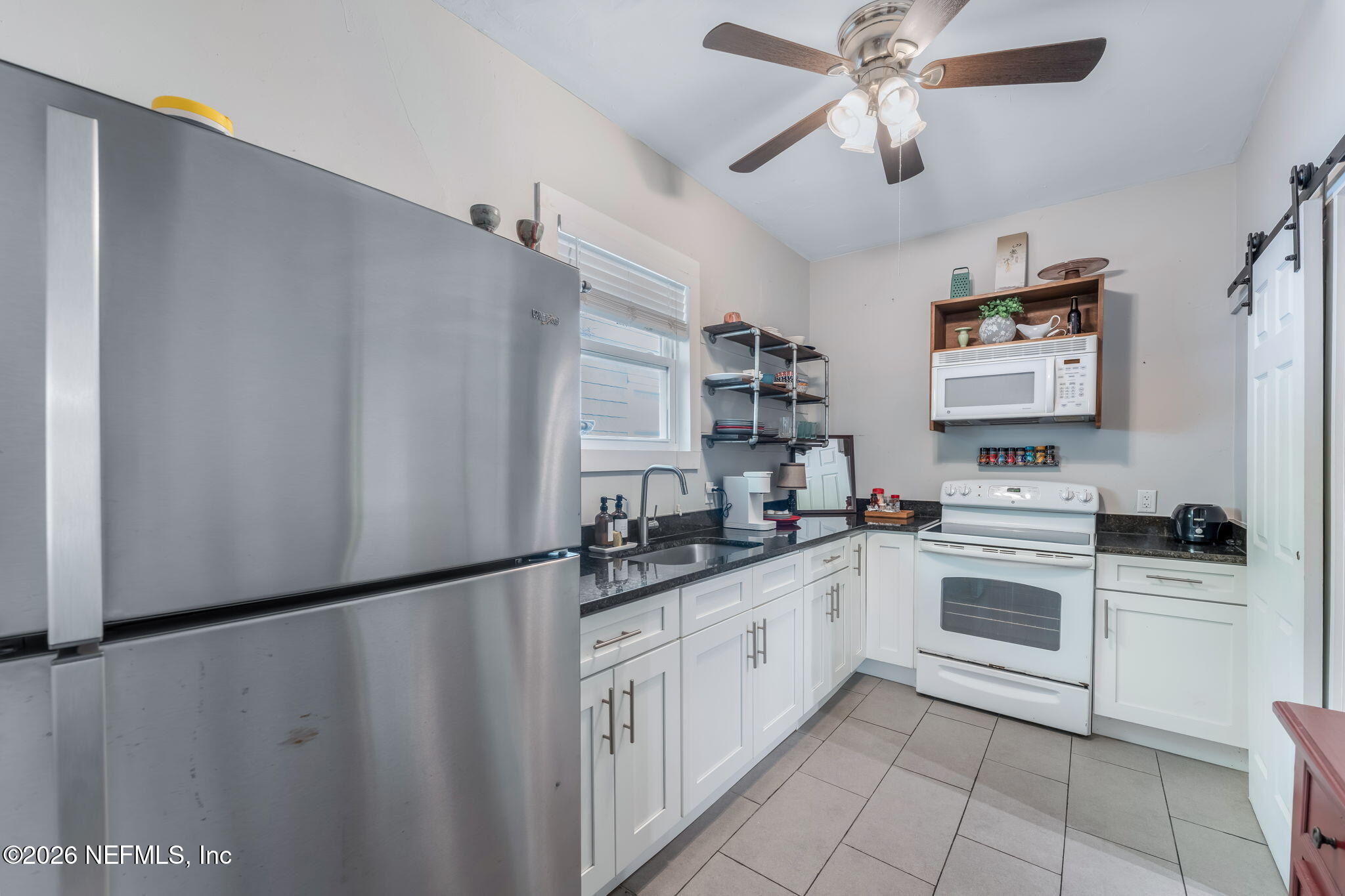 909 Cedar Street Jacksonville, FL 32207 - Photo 30 of 41 a kitchen with stainless steel appliances a refrigerator sink and cabinets