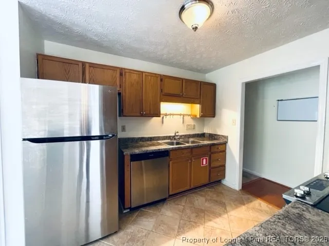 a kitchen with stainless steel appliances granite countertop a refrigerator sink and stove
